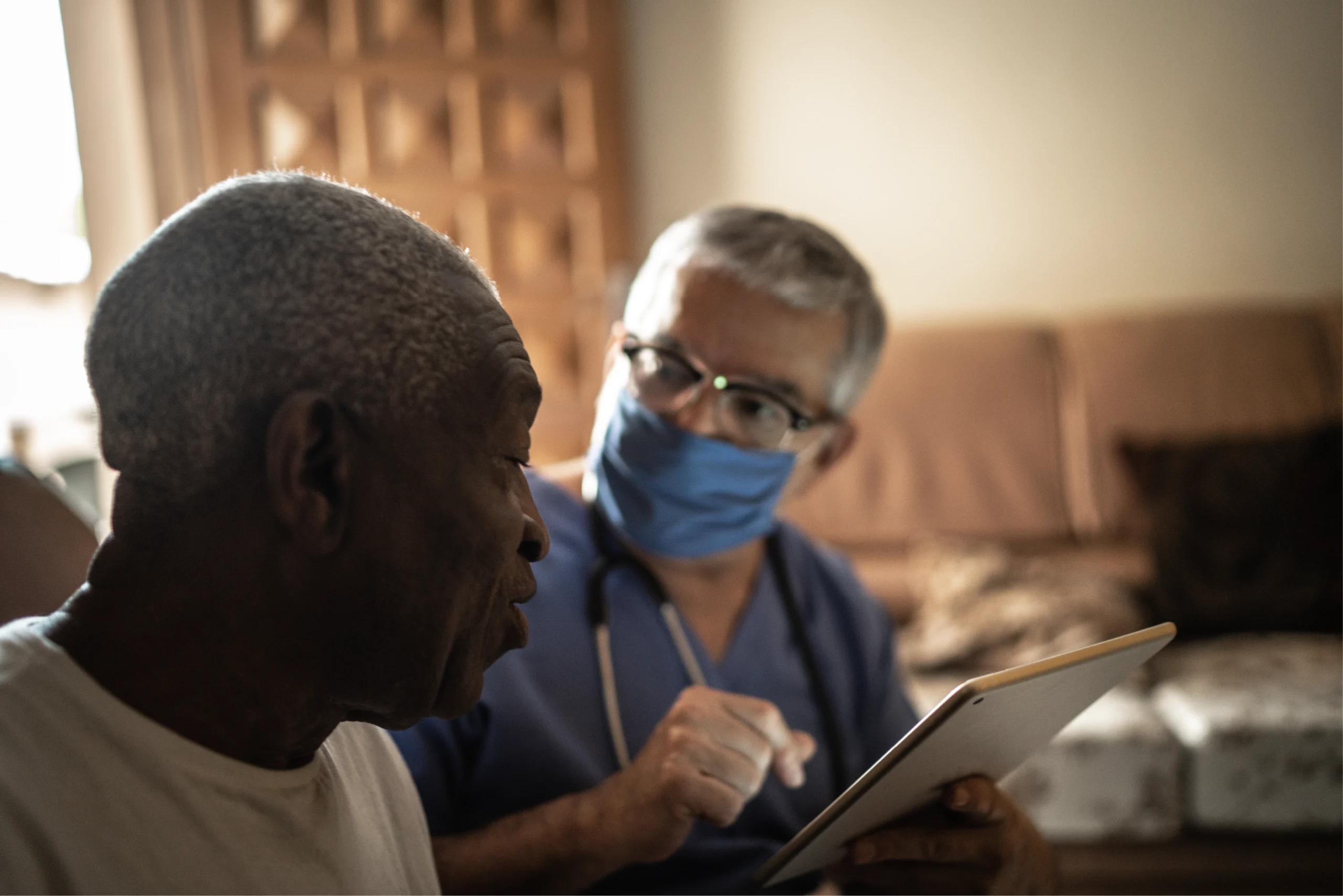 a caregiver wearing a protective mask supporting a senior